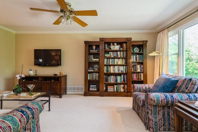 sitting room featuring carpet floors, a ceiling fan, visible vents, and ornamental molding