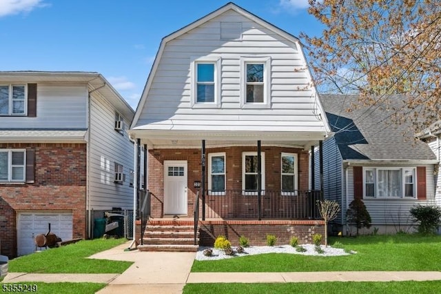 dutch colonial with covered porch, a front lawn, a gambrel roof, and brick siding