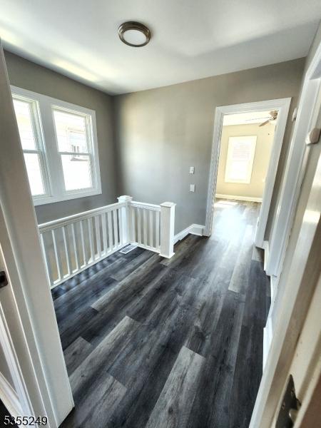 interior space featuring baseboards and dark wood finished floors