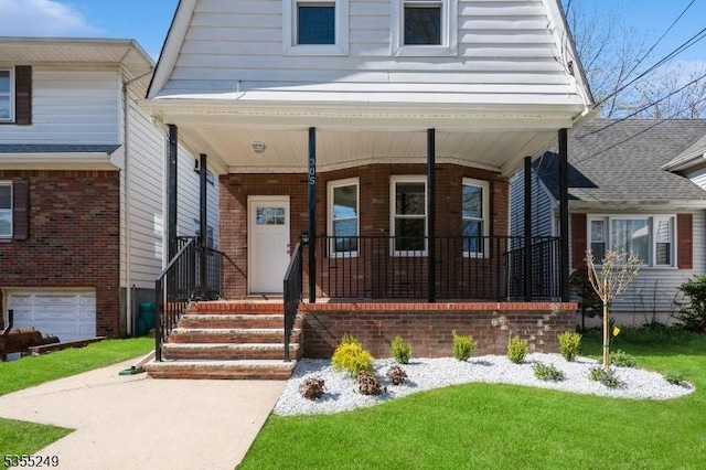 view of front facade featuring covered porch, a front yard, and brick siding