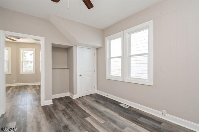 unfurnished bedroom featuring a ceiling fan, baseboards, dark wood finished floors, and visible vents