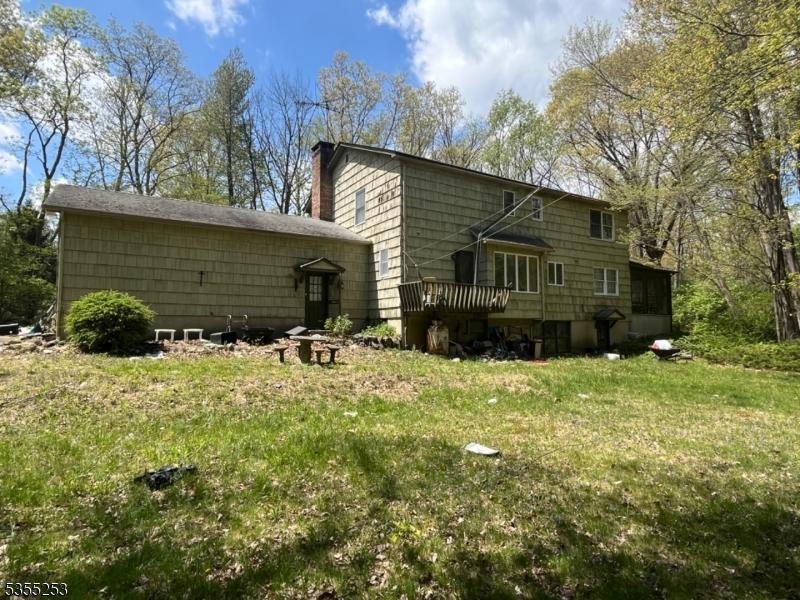 rear view of house featuring a lawn and a chimney