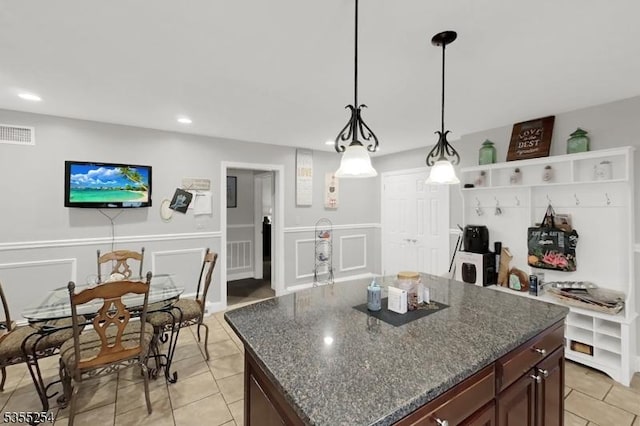 kitchen featuring light tile patterned floors, wainscoting, decorative light fixtures, recessed lighting, and a decorative wall