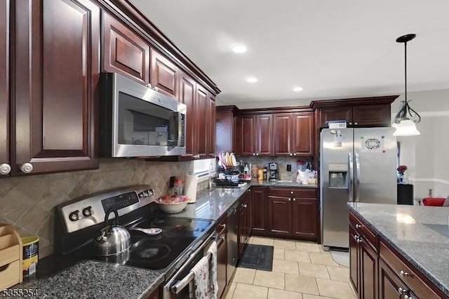 kitchen featuring stainless steel appliances, decorative backsplash, hanging light fixtures, dark stone countertops, and recessed lighting