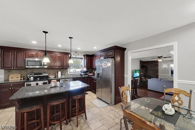 kitchen featuring stainless steel appliances, ceiling fan, decorative backsplash, light tile patterned flooring, and recessed lighting