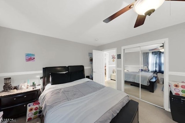 bedroom featuring light colored carpet, a closet, and ceiling fan
