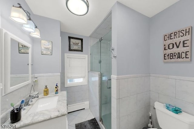 full bath with tile walls, a baseboard heating unit, a stall shower, toilet, and vanity