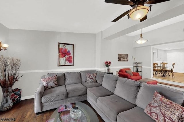 living area featuring wood finished floors, a ceiling fan, and baseboards