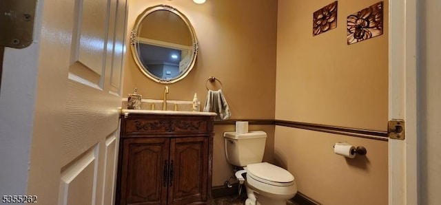 half bathroom with toilet and vanity