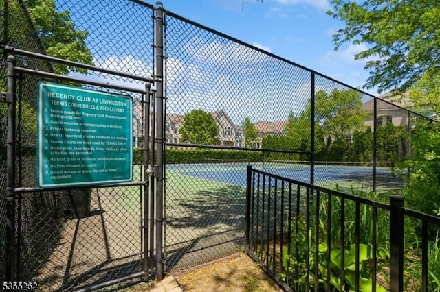 view of sport court with fence and a gate