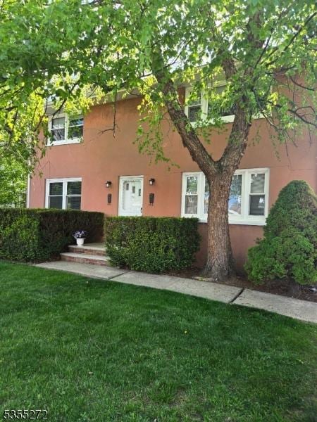 view of property exterior with a lawn and stucco siding