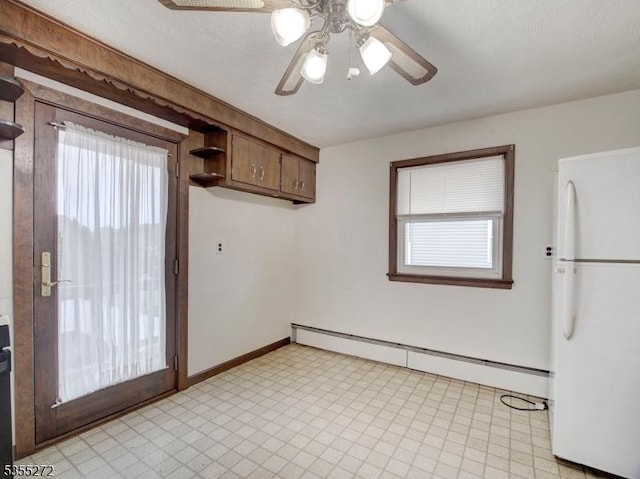 unfurnished dining area featuring ceiling fan, light floors, baseboards, and a baseboard heating unit