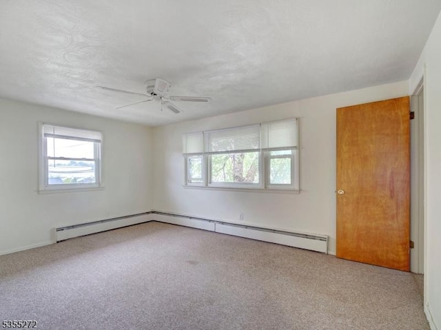 unfurnished room with a wealth of natural light, carpet floors, a ceiling fan, and baseboards
