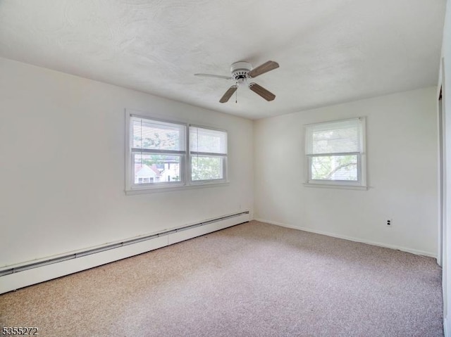 carpeted spare room featuring ceiling fan, a wealth of natural light, baseboards, and baseboard heating
