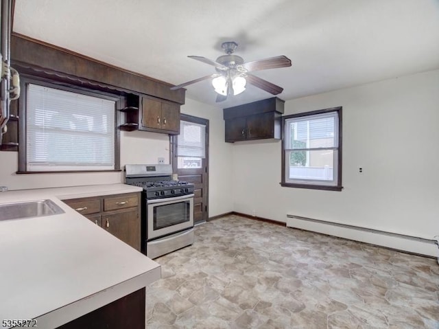 kitchen with a healthy amount of sunlight, a ceiling fan, stainless steel gas stove, and a sink