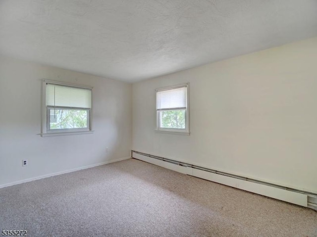 empty room featuring carpet, baseboards, and a baseboard radiator