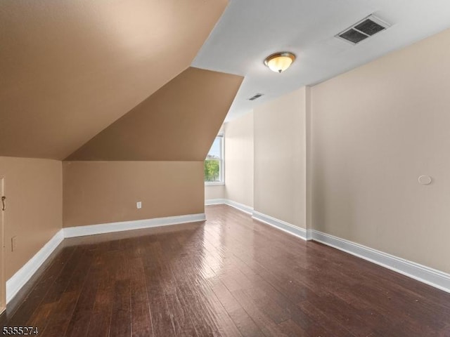 additional living space featuring baseboards, hardwood / wood-style floors, and visible vents
