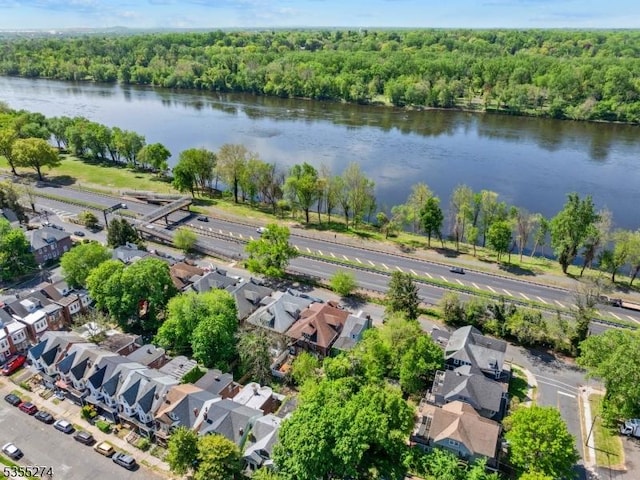 drone / aerial view featuring a water view, a view of trees, and a residential view