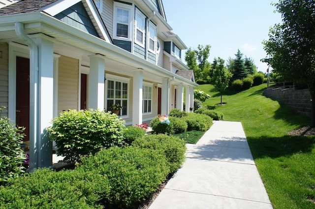 view of home's exterior with covered porch and a yard