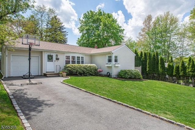 single story home featuring a garage, asphalt driveway, a front lawn, and a chimney