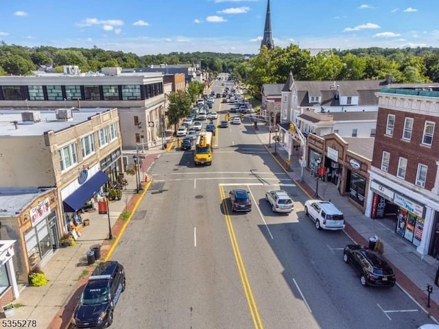 view of asphalt road featuring sidewalks, curbs, and street lights
