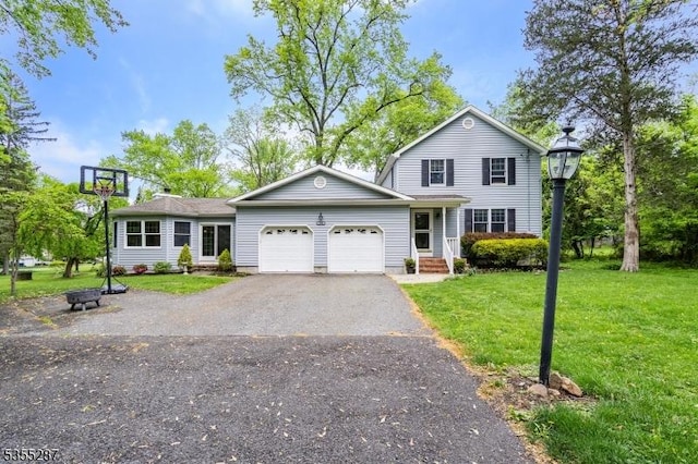 view of front of house with a garage, a front yard, and asphalt driveway