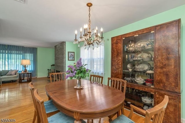 dining room featuring a notable chandelier, a wealth of natural light, and wood finished floors