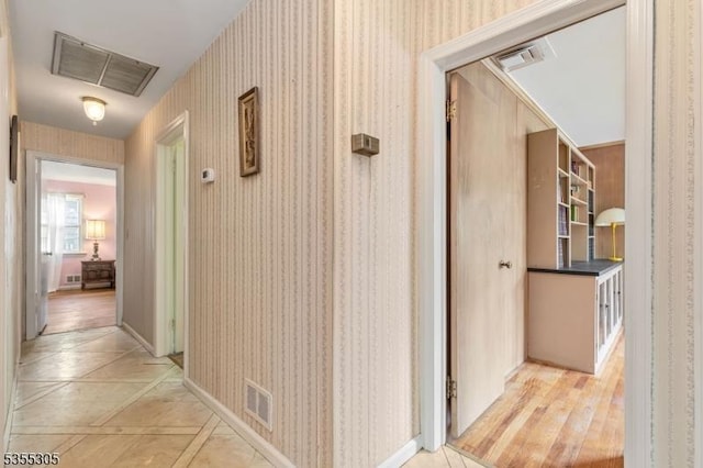 hallway featuring wallpapered walls and visible vents