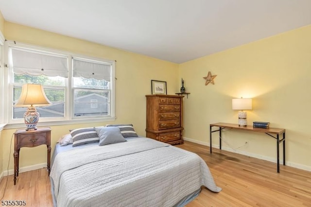 bedroom featuring baseboards and light wood finished floors