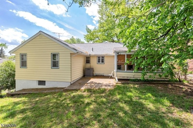 rear view of property with a yard, a sunroom, and a patio area