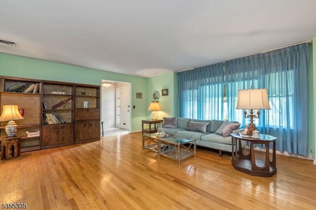 living area featuring visible vents and wood finished floors