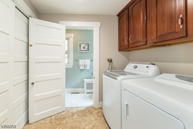 laundry area with washing machine and dryer, cabinet space, radiator, and baseboards