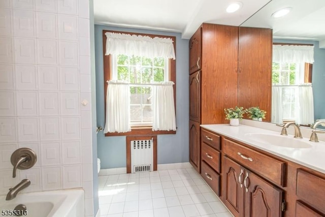 bathroom with radiator, vanity, a tub, tile patterned floors, and baseboards