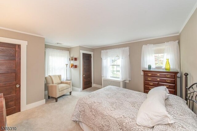 bedroom with light carpet, ornamental molding, and baseboards