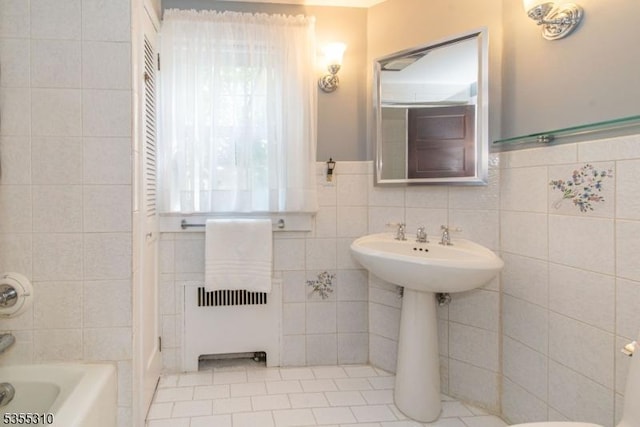 bathroom with tile walls, tile patterned floors, and wainscoting