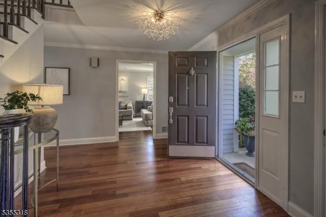 entryway with crown molding, stairs, wood finished floors, baseboards, and a notable chandelier