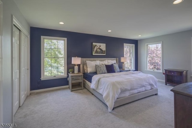 carpeted bedroom featuring recessed lighting, baseboards, and multiple windows