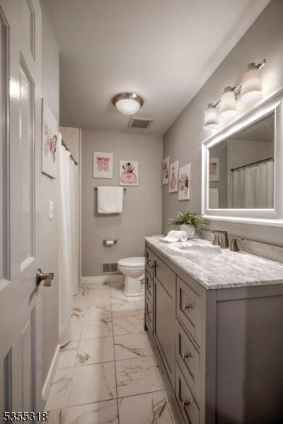 bathroom with vanity, visible vents, marble finish floor, toilet, and baseboards