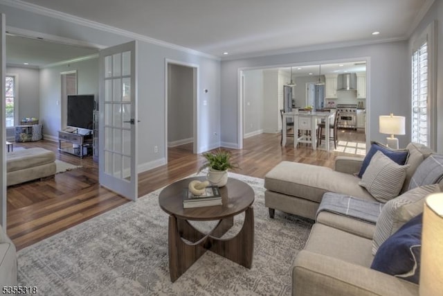 living area with plenty of natural light, light wood finished floors, and crown molding