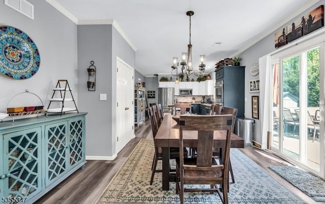 dining area featuring visible vents, dark wood-style flooring, baseboards, a chandelier, and ornamental molding