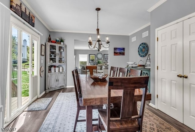 dining area with baseboards, dark wood-style flooring, ornamental molding, visible vents, and a chandelier