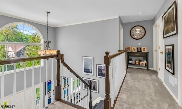 hall featuring crown molding, carpet, baseboards, and an upstairs landing