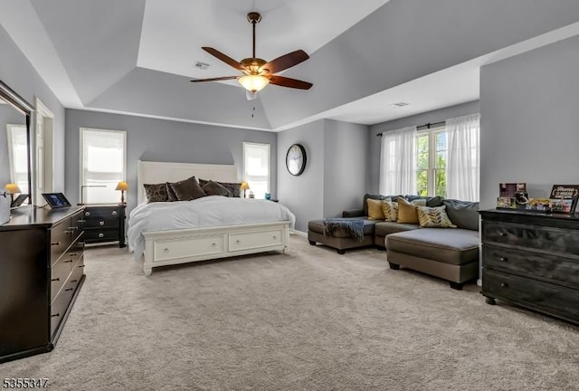 carpeted bedroom with a tray ceiling, visible vents, and a ceiling fan
