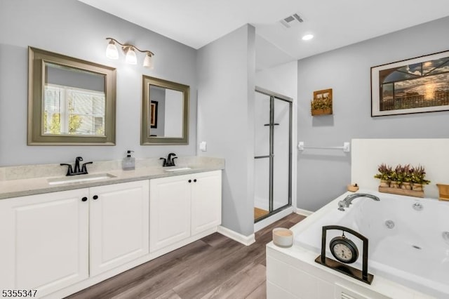 bathroom featuring a shower stall, visible vents, a sink, and wood finished floors