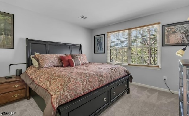 bedroom with visible vents, baseboards, and light carpet