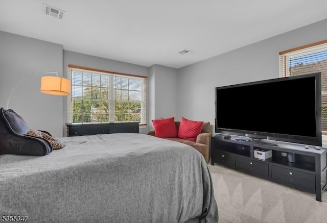 carpeted bedroom featuring visible vents and multiple windows