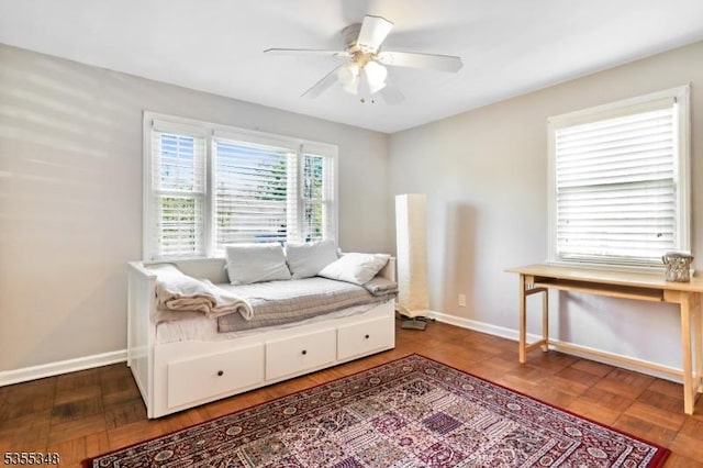 sitting room with ceiling fan and baseboards