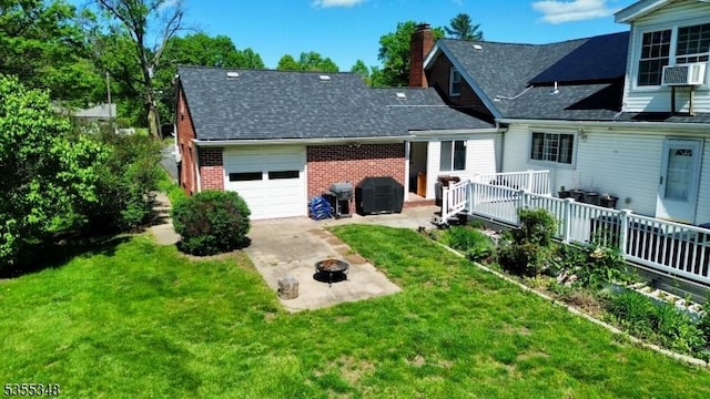view of front of home featuring a garage, a fire pit, brick siding, a chimney, and concrete driveway