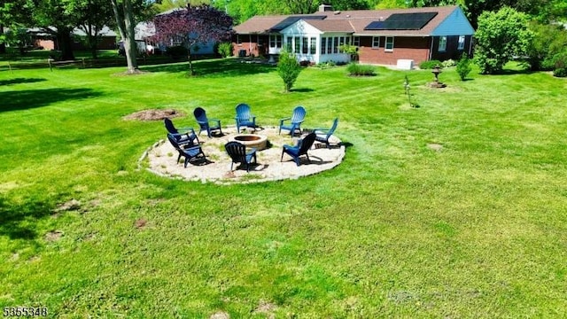 view of green lawn featuring a fire pit