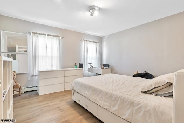 bedroom featuring baseboard heating and light wood-style floors